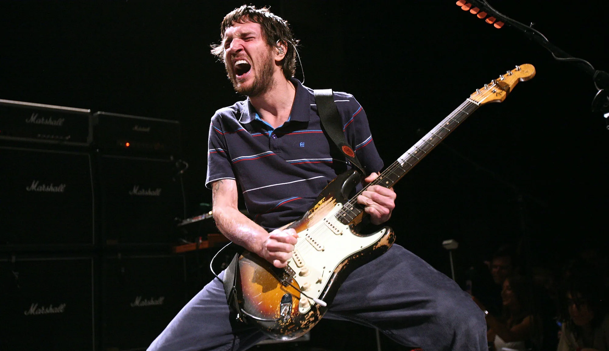 John Frusciante playing guitar onstage.